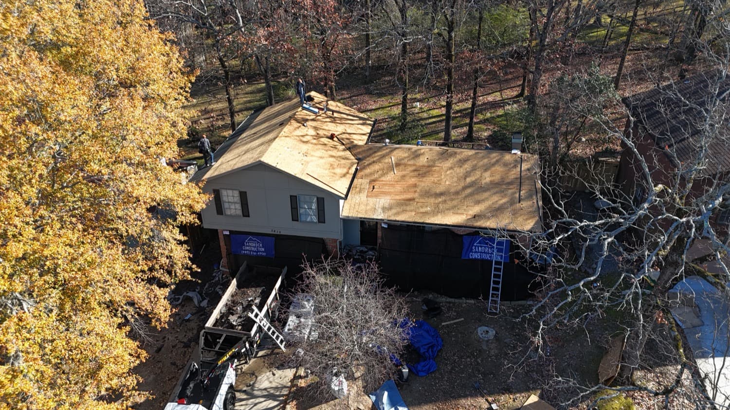 Roof deck replacement in progress on a wooded property