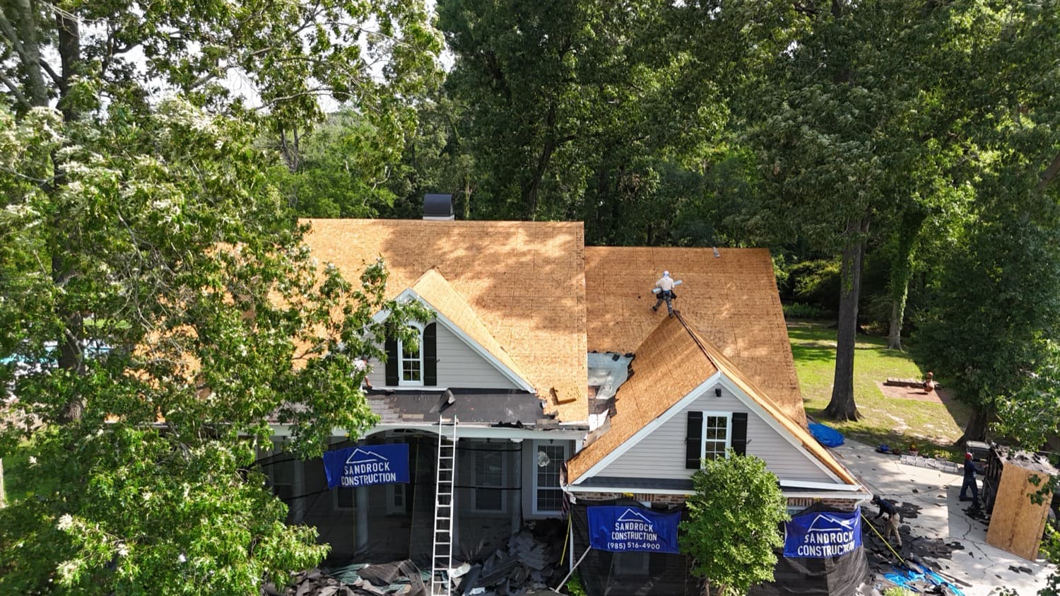 Residential tear-off and reroof in progress with crew on the roof